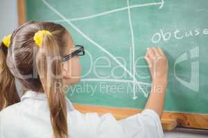 Pupil with lab coat writing on chalkboard in a classroom