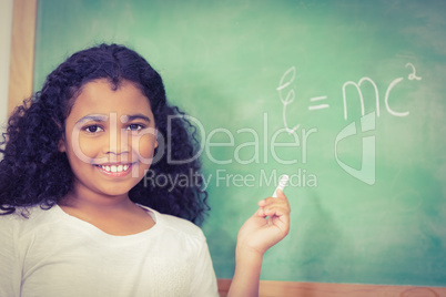 Smiling pupil standing in front of chalkboard