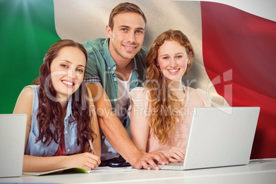 Composite image of fashion students using laptop