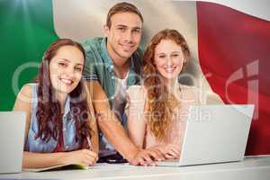 Composite image of fashion students using laptop