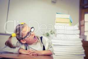 Pupil looking shocked at stack of books on her desk