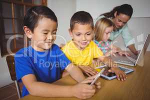 Cute pupils in class using laptop and tablet