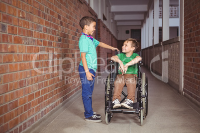 Smiling student in a wheelchair and friend beside him