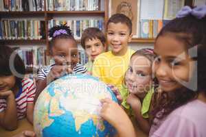 Pupils looking at globe in library