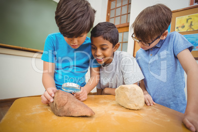 Pupils looking at rock with magnifying glass