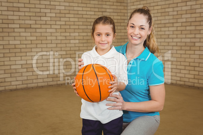 Student holding basketball with teacher