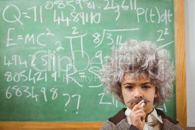 Little Einstein thinking in front of chalkboard