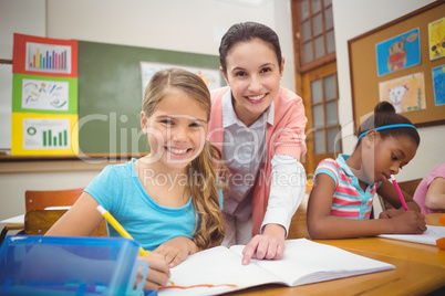 Pupil and teacher smiling at camera during class