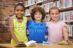 Happy pupils reading a library book