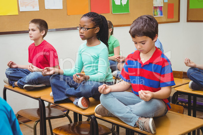 Pupils meditating on classroom desks