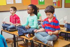 Pupils meditating on classroom desks