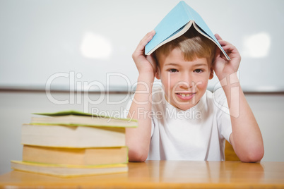 Student holding book over their head