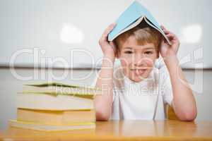 Student holding book over their head