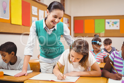 Teacher helping a little girl during class