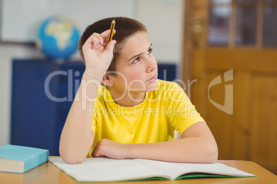 Concentrated pupil working at his desk in a classroom