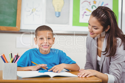 Smiling pupil being helped by teacher