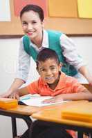 Teacher helping a little boy during class