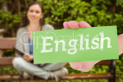 English against smiling student sitting on bench listening music