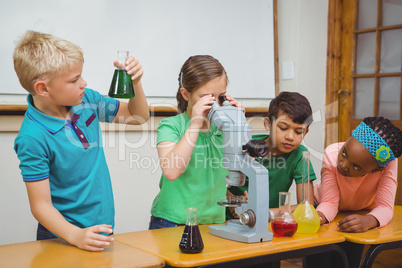 Students using science beakers and a microscope
