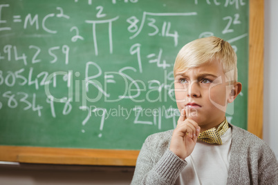 Pupil dressed up as teacher thinking in front of chalkboard