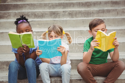 Students sitting on steps and reading books