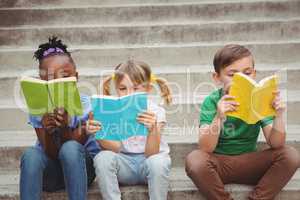 Students sitting on steps and reading books