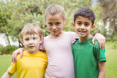 Happy children standing together with arms around each other