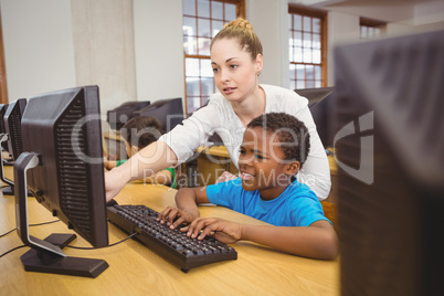 Teacher showing students how to use a computer