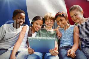 Composite image of happy children using digital tablet at park