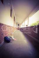 Sad pupil sitting alone on ground