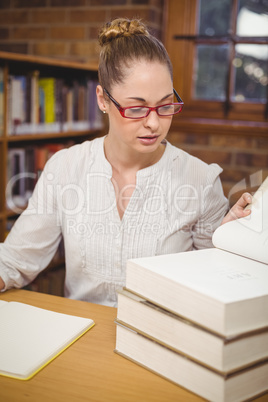 Blonde teacher reading books in the library