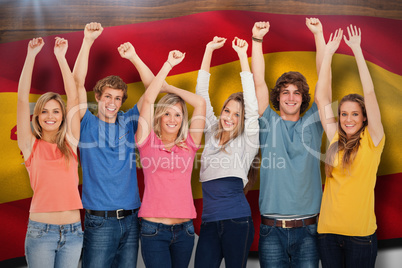 Composite image of a group of people with their hands raised