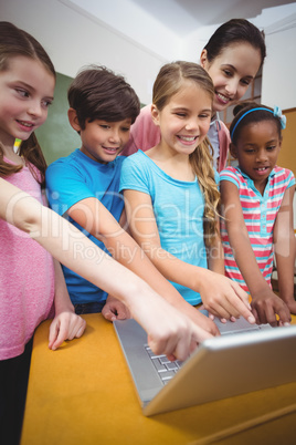 Teacher and pupils looking at laptop