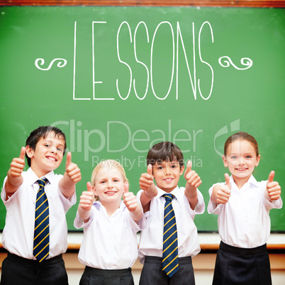 Lessons against cute pupils showing thumbs up in classroom