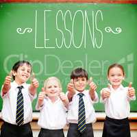 Lessons against cute pupils showing thumbs up in classroom