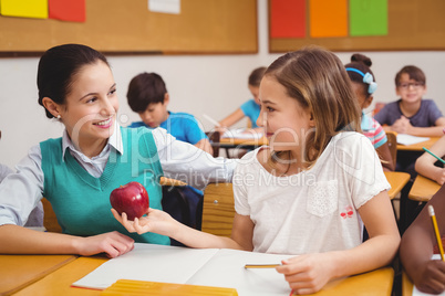 Pupil offering an apple to teacher