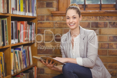 Blonde teacher searching book in the library