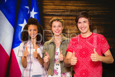 Composite image of college students gesturing thumbs up in libra