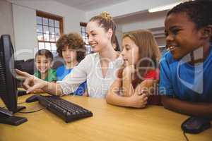 Teacher showing students how to use a computer