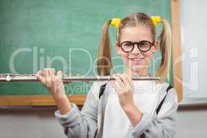 Cute pupil with flute in a classroom