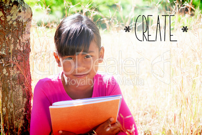 Create against cute little girl reading in park