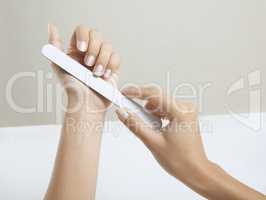 Frauenhände mit Nagelfeile