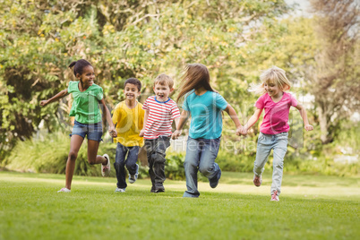 Happy classmates running and holding hands