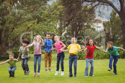 Cute pupils cheering on the grass outside