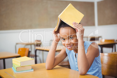 Student holding a book over her head