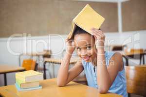 Student holding a book over her head