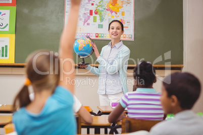 Pupils listening to their teacher holding globe