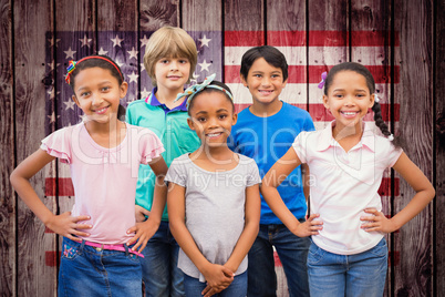 Composite image of cute pupils smiling at camera in classroom