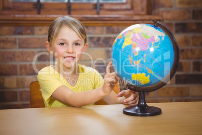 Students pointing at a globe