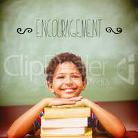 Encouragement against little boy with stack of books in classroo